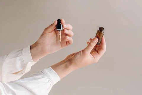 Close-up of a Woman's hands applying essential oil on her wrist indoors Foto stock