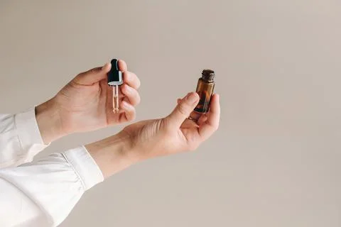 Close-up of a Woman's hands applying essential oil on her wrist indoors Stock Photos