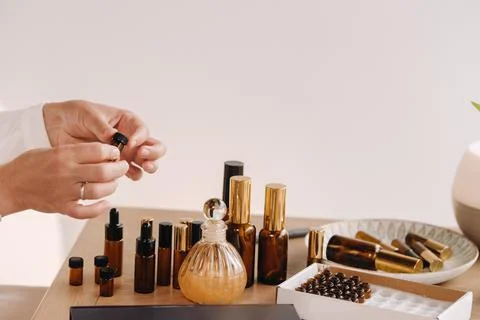 Close-up of a Woman's hands applying essential oil on her wrist indoors Stock Photos
