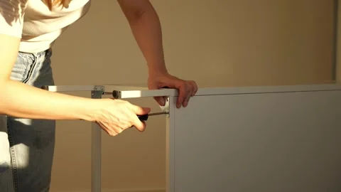 Close up of woman’s hands assembling flat pack furniture with screwdriver Stock Footage 319405212
