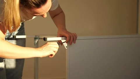 Close up of woman’s hands assembling flat pack furniture with screwdriver Stock Footage 319405224