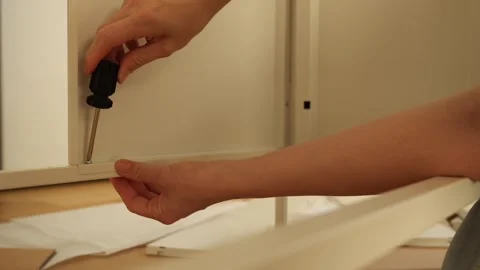 Close up of woman’s hands assembling flat pack furniture with screwdriver Stock Footage 319405972