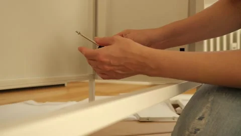 Close up of woman’s hands assembling flat pack furniture with screwdriver Vidéo 319406061