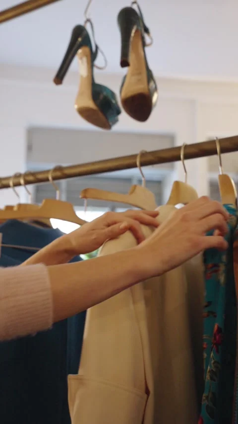 Close-up of a woman’s hands browsing clothes on a rack Stock Footage 331537799