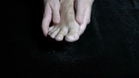 Close-up of a woman's hands brushing and massaging her toes on her bare foot Stock Footage 149441400