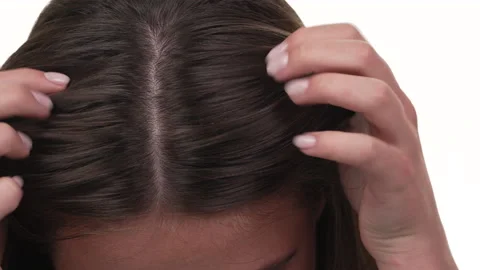 Close up of a woman's hands checking her hair on her head. Isolated on white Video stock 197440654