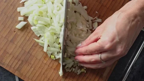 A close-up of a woman's hands chopping onions finely. Dice onions. Stock Footage 305634961