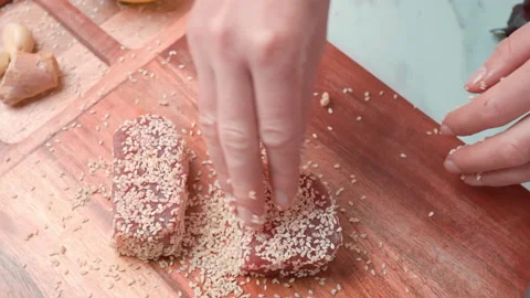 Close-up of woman's hands Coating raw tuna in sesame seeds in 4K. Stock Footage 141302356