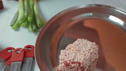 Close-up of woman's hands Coating raw tuna in sesame seeds in 4K. Stock Footage 141303205