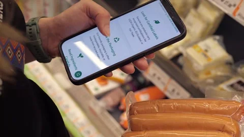 Close-up of a womans hands comparing eco-labeled products in a supermarket. She Stock-Footage 318172799
