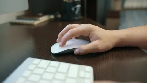 Close-up of a woman's hands controlling a computer mouse while working at home. Vidéo 217394593