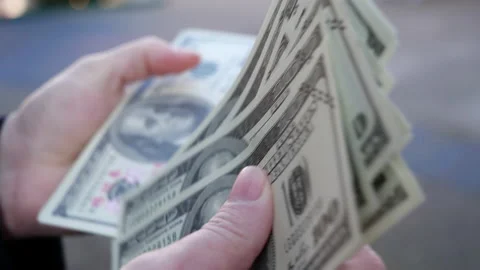 Close up of woman's hands counting a stack of 100 dollar bills USD Stock Footage 143660683