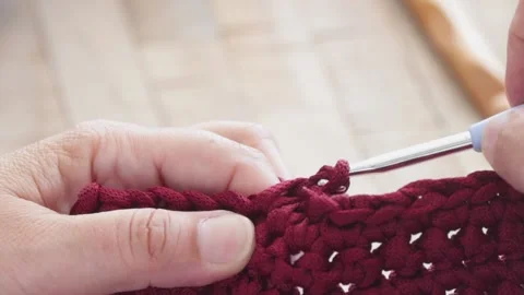 Close-up of woman's hands crocheting with red yarn Stock Footage 130605590