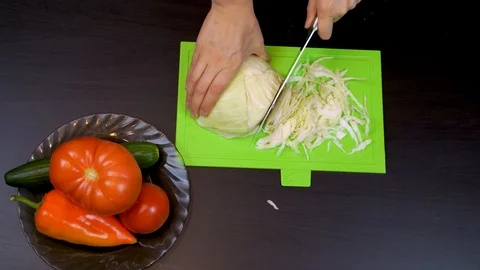 Close-up of woman's hands cutting cabbage in kitchen Stock Footage 99044459