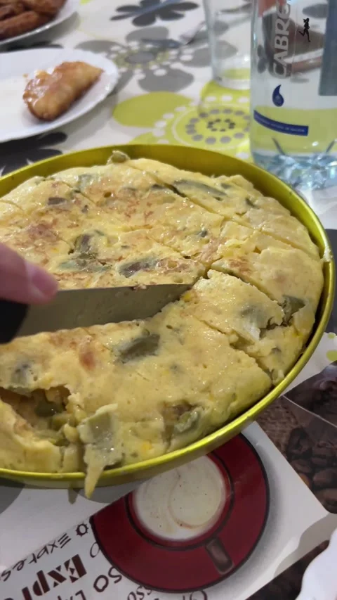Close-up of a woman's hands cutting a potato omelet Stock Footage 221172618
