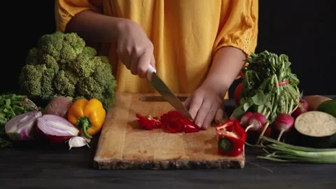 Close up of woman's hands cutting red pepper into small pieces surrounded by  Stock Footage 145242270