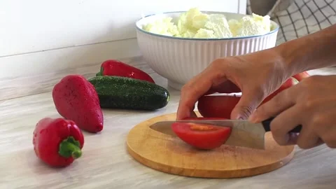 Close-up of woman's hands cutting tomato on cuting board in the kitchen 스톡 동영상 248760707