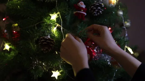 Close-up of woman's hands decorating Christmas tree with balls and stars Stock Footage 143998629