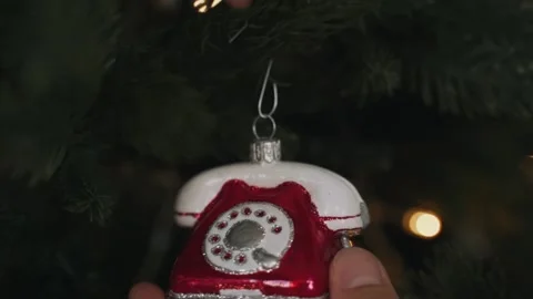 Close-up of woman's hands decorating Christmas tree with telephone toy Stock Footage 165248068