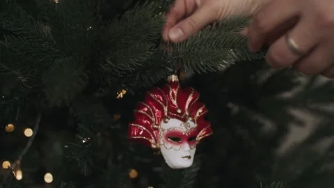 Close-up of woman's hands decorating Christmas tree. Venetian mask Stock Footage 166544388
