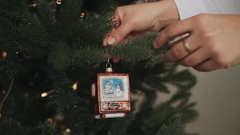 Close-up of woman's hands decorating Christmas tree. Retro television Stock Footage 166544423