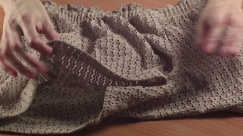Close-up of woman's hands examining new shorts at home on a table Vídeo Stock 316501139