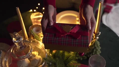 Close up of woman's hands give a gift near the Christmas tree Stock Footage 221881975