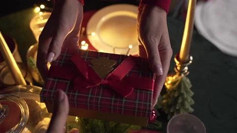 Close up of woman's hands give a gift near the Christmas tree Stock Footage 221975195