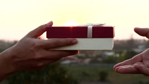 Close-up of woman's hands giving gift box with white ribbon as a surprise Stock Footage 232906419