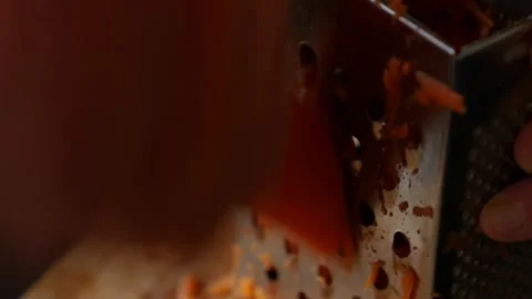 Close-up of a woman's hands grates carrots on a grater. Housewife grates carrot Stock Footage 166376915