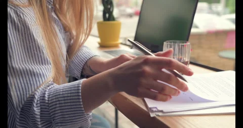 Close up woman's hands hold pen and work with papers in coffee shop. Stock-Footage 274845170