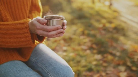 Close up of woman`s hands holding cup of hot tea. Happy smiling girl rests in Stock Footage 114518384
