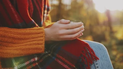 Close up of woman`s hands holding cup of hot tea. Tourist girl wearing tartan Stock Footage 114525065