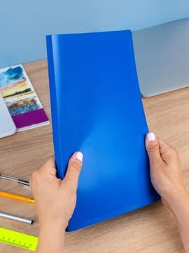 Close up of a woman's hands holding documents in a sleeve in a plastic folder Stock Photos