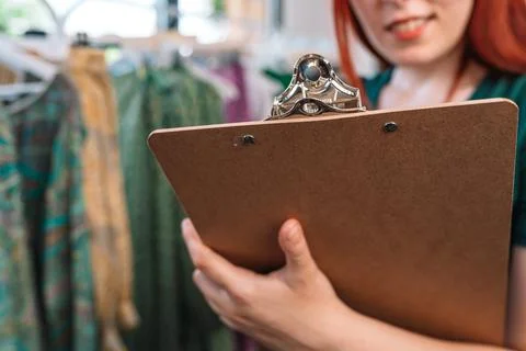 Close-up of a woman's hands holding a folder in a fashion shop. woman Stock Photos