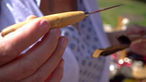 Close-up of woman's hands holding handmade knife with wooden handle in a Vidéo 114693906