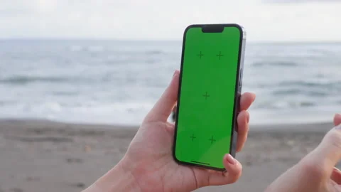 Close-up of a woman's hands holding a vertical mobile phone and zooming the Stock Footage 220701475