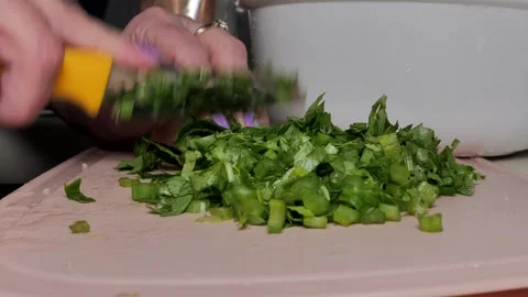 Close-up of woman's hands with a knife slicing green salad in a kitchen Stock Footage 251807053
