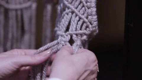 Close up of a woman's hands knotting a boho macrame vest Stock Footage 127039983