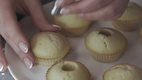 Close-up, Woman's Hands Make Holes in Cupcakes Stock Footage 106597129