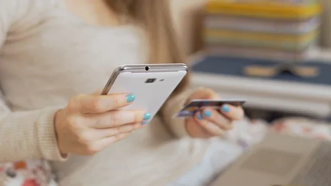 Close-up of a woman's hands making purchases online using a credit card using a  Video stock 124520522