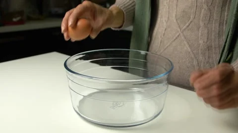 Close up woman's hands open an egg for sweet preparation. Slow motion HD Stock Footage 171881550