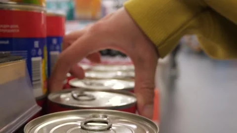 Close-up of a woman's hands or a shopper selecting a can of canned goods Stock Footage 295880254