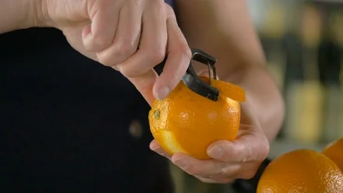 Close-up of woman's hands peeling an orange at a restaurant bar. Stock Footage 113693245