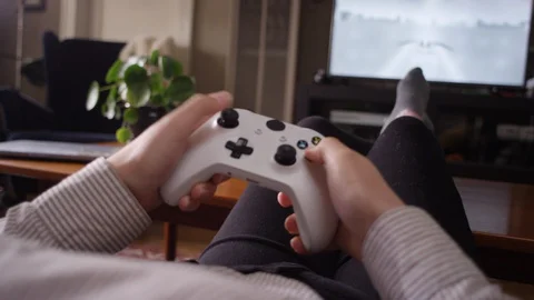 Close-up of a woman's hands playing a videogame with a controller 動画素材 129073373