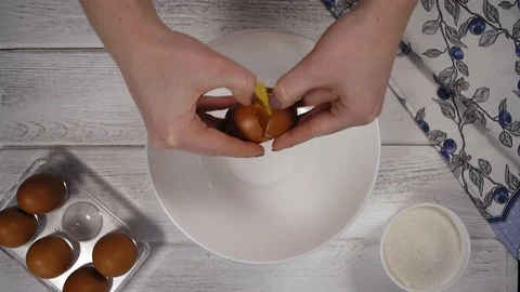 Close-Up, Woman's Hands Poured Egg Yolk from White Shell into a White Plate Stock Footage 102584061