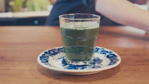 Close up of woman's hands preparing a green barley juice from powder using a jar Stock Footage 273510756