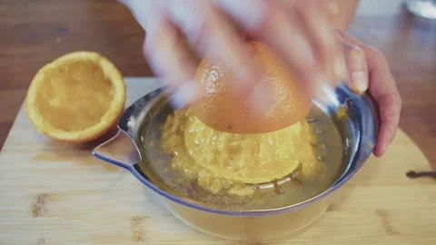 Close up of woman's hands pressing, squeezing orange juice using manual juicer Stock Footage 273510359
