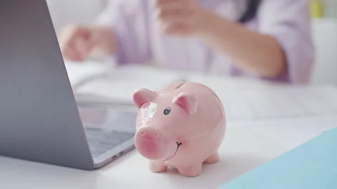 Close-up of woman's hands putting coins into piggy bank, saving money, planning Stock Footage 191968170