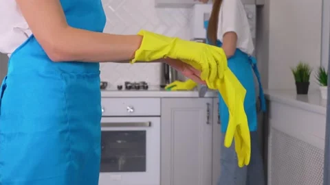 Close-up of woman's hands putting on gloves before cleaning. 库存影片 231329843